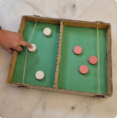 Jogo de mesa construído com caixa de papelão e elásticos